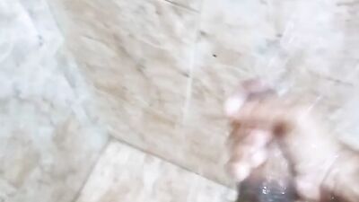 muscled man jerks off under the shower water, shows and massages his huge, hard cock until cumming, his milk is delicius