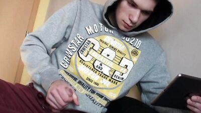 Cute gay guy passes the time with erotic masturbation until he comes to cum