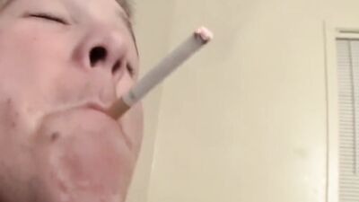 Straight lad is jerking his cock while he's smoking a cigarette