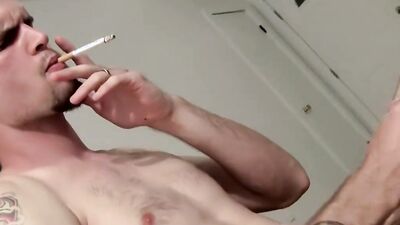 Amateur bloke is smoking a cigarette and jerking his cock