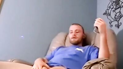 Lad jerks his huge cock in front of the tv