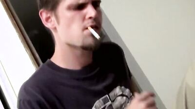 Straight bloke is jerking his hard cock while smoking a cigarette