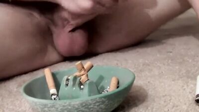 Straight bloke is jerking his hard cock while smoking a cigarette