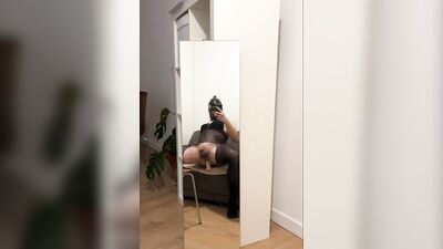 Riding cock with latex mask in front of a mirror
