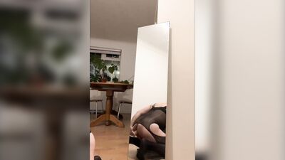 Riding cock with latex mask in front of a mirror
