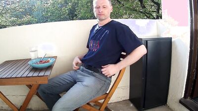 Man outside on the balcony eating lunch undress and starts wanking his penis is soon erect