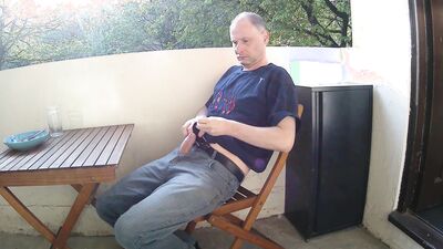 Man outside on the balcony eating lunch undress and starts wanking his penis is soon erect and he is naked as he wanks