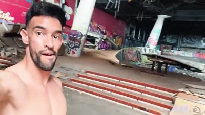 Fitness man walking fully naked on abandoned building