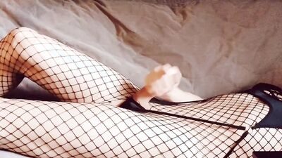 Cute femboy in fishnets strokes his erect cock, moans and cums