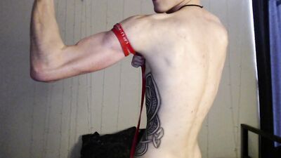 Endo shows off his biceps by pulling on a rubber band for better visibility.