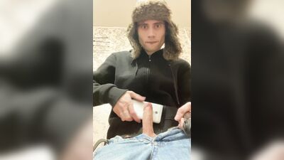 A guy in a jacket and a hat masturbates and cums upside down on his jacket