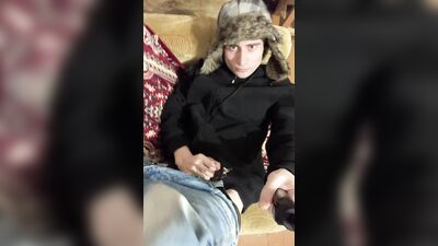 A guy in a jacket and a hat masturbates and cums upside down on his jacket
