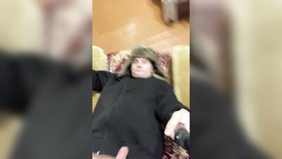 A guy in a jacket and a hat masturbates and cums upside down on his jacket