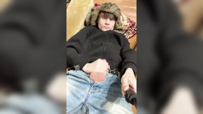 A guy in a jacket and a hat masturbates and cums upside down on his jacket