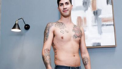 Good looking tattooed gay bloke is masturbating on the couch