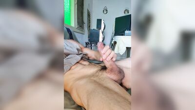 Shiny pink cock cums on black pubic hair.