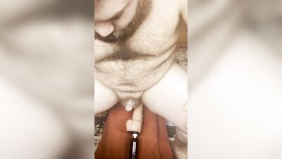 Riding a thick toy on fuck machine while caged