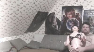 Fat bloke plays with his doll in front of the camera