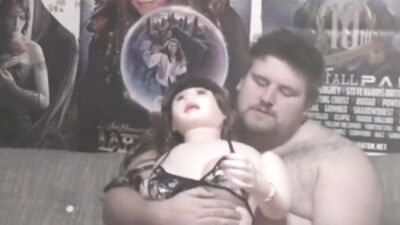 Fat bloke plays with his doll in front of the camera